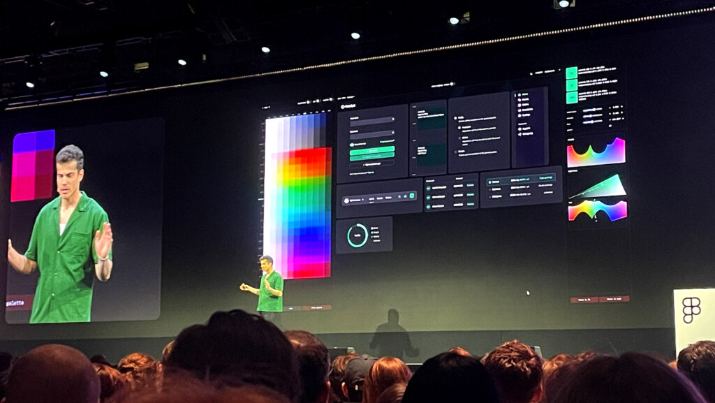 Dan Hollick, Design Engineer at Tailwind CSS presenting on stage behind him a big screen showing a colour palette